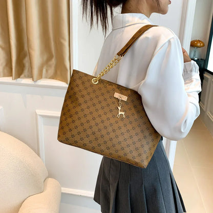 Brown leather tote bag worn on shoulder with large capacity and structured design